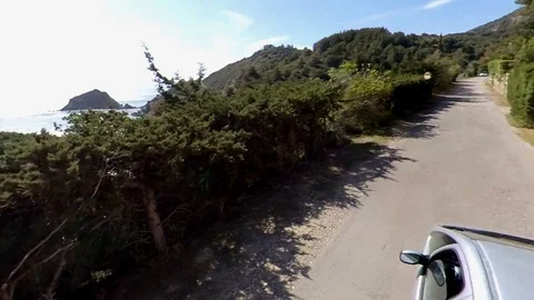 VR360 effect a car runs along a panoramic road on the sea in a sunny evening Stock Footage 107192570