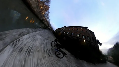 VR360 Effect Rome, A man ride a Bike along the river on Tiberina Island at Dusk Stock Footage 100315702