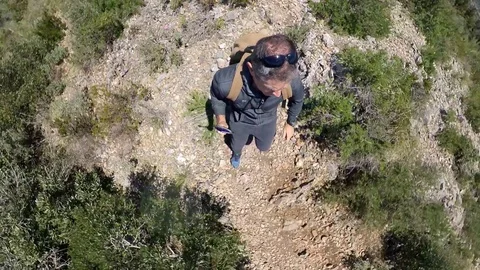 VR360 effect A trekker runs on rough path on a mountain overlooking the sea Stock Footage 107192507