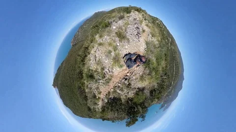 VR360 effect A trekker runs on rough path on a mountain overlooking the sea, in  Stock Footage 107192552