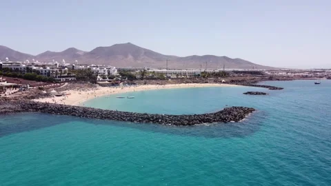 Vuelo de dron sobre las aguas azules de Playa Blanca en Lanzarote en 4k 動画素材 158237379