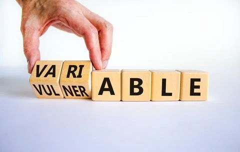 Vulnerable or variable symbol. Businessman turns wooden cubes and changes the Stock-Fotos