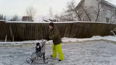 VV2724 Guy ice skates with monkey in a baby carriage Stock-Footage 129461429