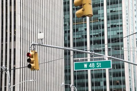W 48th St intersection with traffic light, New York City skyscrapers backgrou Stock Photos