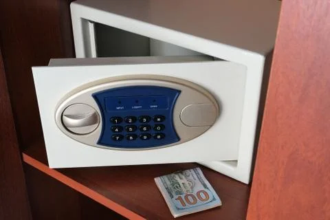 A wad of dollars and an open safe in the closet. Keeping money in a safe plac Stock Photos