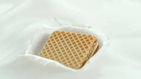 Wafer Candy Bar Falling into Creamy Milk Making Splash in Macro Stock Footage 274354936