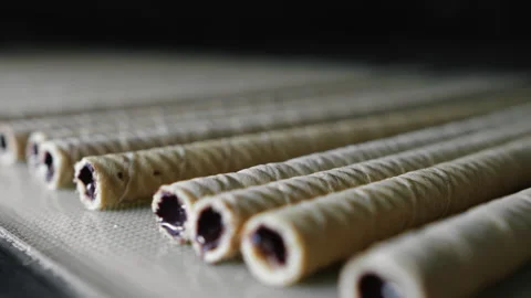Wafer rolls with chocolate inside move along a conveyor. Stock Footage 295129357