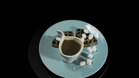 Waffle dark hearts on a blue plate with coffee cup on black background. Stock Footage 101935013