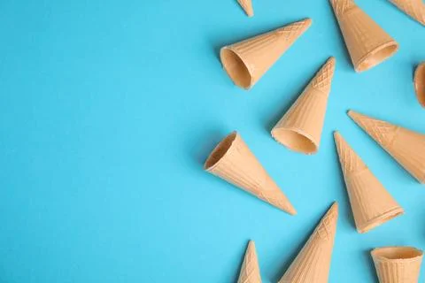 Waffle empty ice cream cones on color background, flat lay. Space for text Stockfoto's