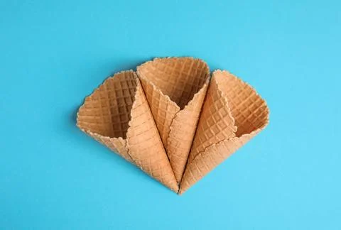 Waffle empty ice cream cones on color background, flat lay Stockfoto's