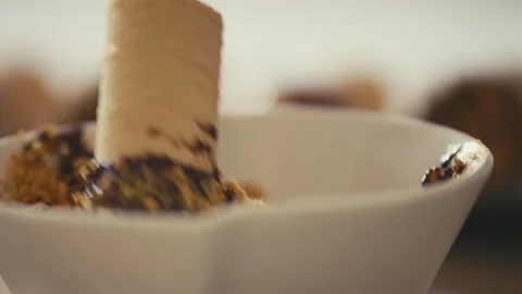 Waffle roll dipped into chocolate rolled in nuts Stock Footage 274635178