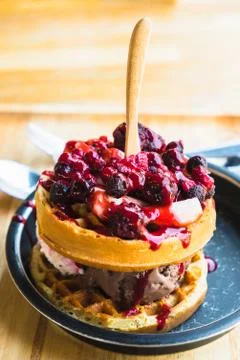 Waffles and chocolate icecream with fresh berries on wooden tray Stock Photos