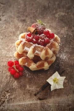 Waffles and raspberries on rustic table Stock Photos