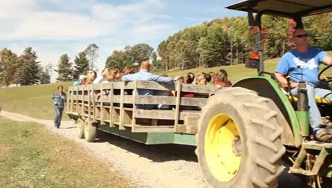 Wagon full of families pulled by tractor Stock Footage 8958365