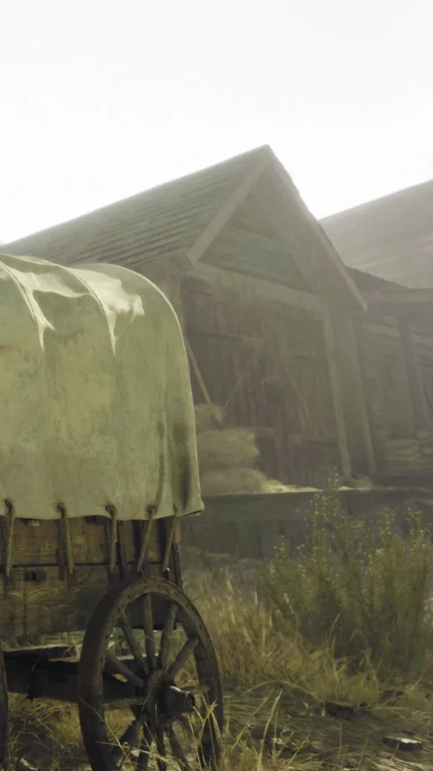 Wagon sits near a rustic barn in early morning light on a quiet farm Stock Footage 332212896