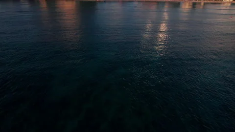 Waikiki drone camera tilt up fly towards hotels during golden hour Stock Footage 170232758