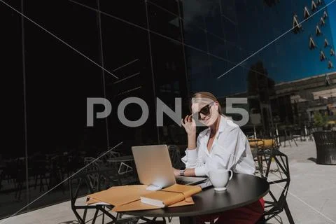 Waist up of beautiful businesswoman wearing sunglasses and looking at camera Stock Photos