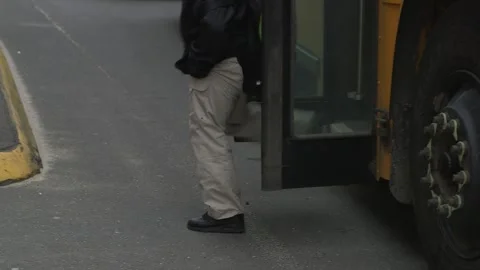 Waist down shot of children getting off school bus, handheld Stock Footage 304366699