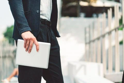 Waist down unrecognizable man side view holding a digital tablet in his hand Stock Photos