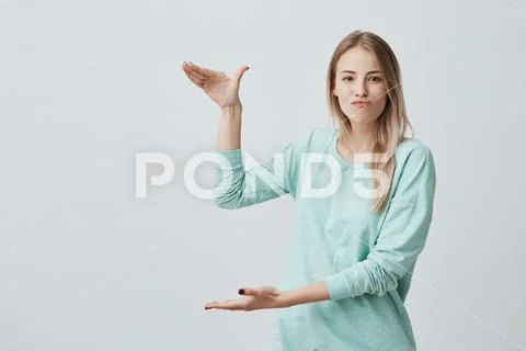 Waist-up portrait of caucasian female model with blonde hair pouting her lips Stock Photos