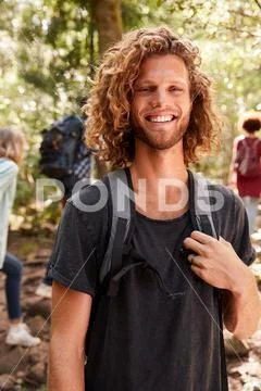 Waist up portrait of smiling millennial white man hiking in a forest, close up, Stock Photos