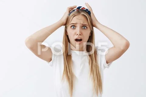 Waist-up shot of concerned panicking young feminine blonde woman in headband Stock Photos