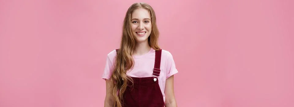 Waist-up shot of kind friendly-looking pleasant young female student with long Stock-Fotos