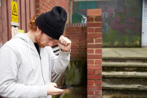 Waist up view of young man using phone in an urban setting Stock Photos