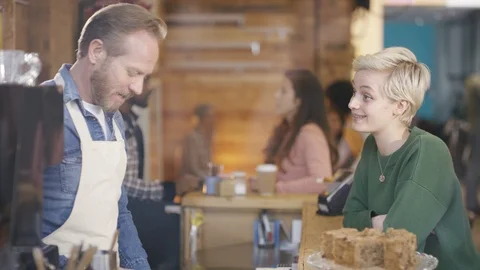 Waiter accepting payment from customer after serving coffee at counter Stock Footage 108016054