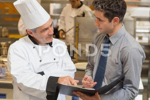 Waiter and chef discussing the menu Stock Photos