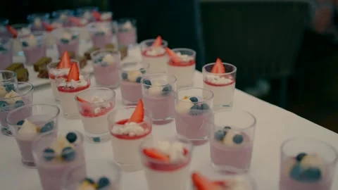 A waiter arranges desserts on the table in a restaurant for guests. Video stock 231426697