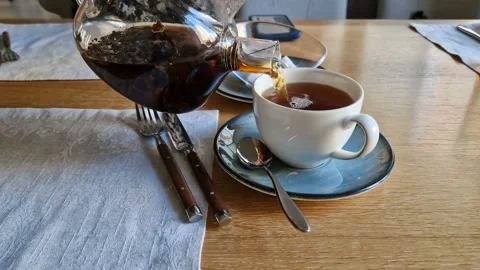 A waiter in a cafe pours tea into a white mug Stock Footage 204708294