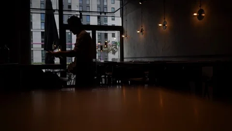 Waiter covers tables in restaurant silhouette Stock Footage