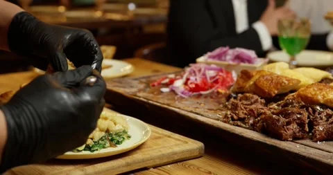 The waiter cuts the finished meat and runs the table in the restaurant Stock Footage 263439062