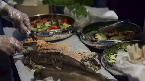 The waiter cuts a  salmon on a buffet Stock Footage 83001387