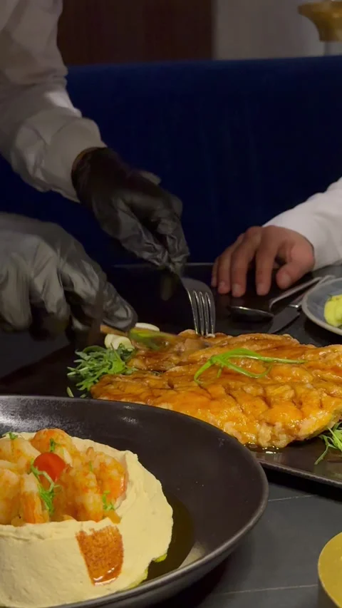 Waiter cutting a whole crispy fried fish at a luxury restaurant table Vídeo Stock 337636039