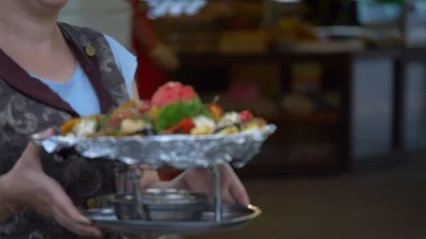 The waiter delivers to the table cooked in a cauldron vegetables. Stock Footage 124731691