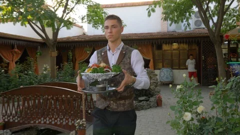 The waiter delivers to the table cooked in a cauldron vegetables. Stock Footage 126269488