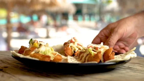 Waiter hand closeup serving fish tacos plate outdoors Video stock 115545644