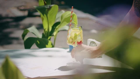 Waiter hand puts on a table beautiful refreshing fruit cocktail in a summer city Stock-Footage 246180888