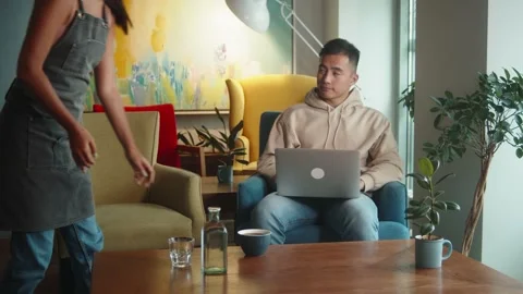 Waiter hand serving cup of coffee to smiling asian man male customer in cafe Stock Footage 159024576