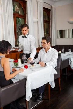 Waiter happily accommodating couple Stock Photos
