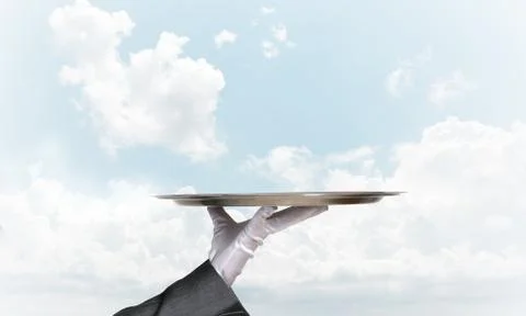 Waiter holding empty silver platter ready for product or item placement Stock Photos