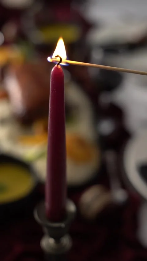A waiter is lighting a red candle with a match during a romantic dinner, close Stock Footage 334345805