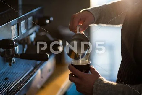 Waiter Making Cup Of Coffee At Counter In Cafe