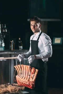 The waiter or cook gets dry meat in the refrigerator. Stock Photos