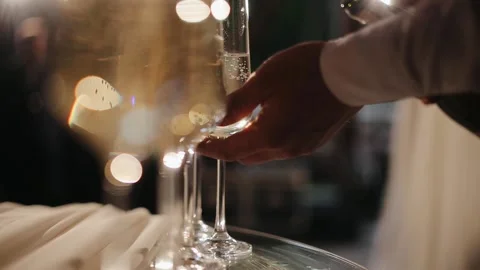 Waiter is pouring champagne. Pour the champagne into a glass. Bartender pouring Stock Footage