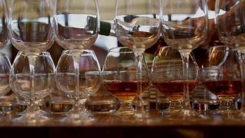 The waiter pours brandy into the glasses Stock Footage 119600097