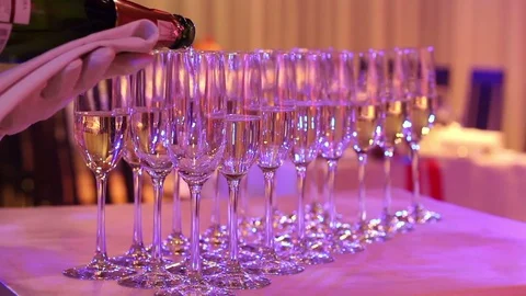 The waiter pours champagne into glasses, champagne glasses on the buffet table Stock Footage