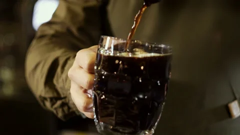The waiter pours dark beer into a large beer mug Stock Footage 101751046
